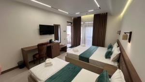 a hotel room with two beds and a desk at Shams Boutique Hotel in Bukhara