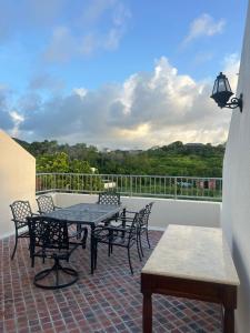 a patio with a table and chairs on a balcony at Villa Ray in Gros Islet