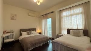 a bedroom with two beds and a window at 金門58旅宿 可包棟 好停車 近市區 近金門大橋 in Hsia-pu-hsia