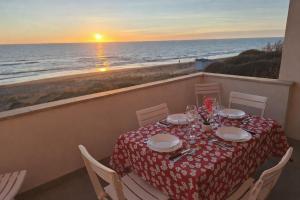 a table on a balcony with a view of the ocean at My Sunset in Torvaianica