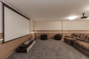 a large screen in a room with two couches at Ermensai Wellness Boutique Hotel in Almaty