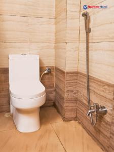 a toilet in a bathroom with a wooden wall at RAILVIEW HOTEL- Nr Platform-1, Railway Station in Bhubaneshwar