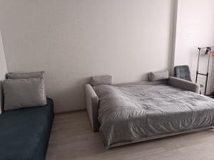 a small bedroom with a bed and a couch at Квартира Одесская in Odesa