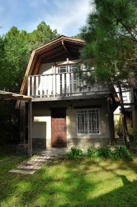 a house with a porch and a balcony on top of it at Cabañas Balboa in Costa del Este