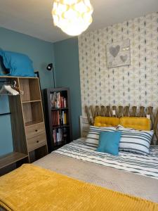 a bedroom with a bed with yellow and blue pillows at Maison cocconing proche Reims in Boult-sur-Suippe