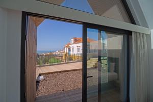 a sliding glass door with a view of a house at Boomerang d'O Século in Ericeira +46 photos