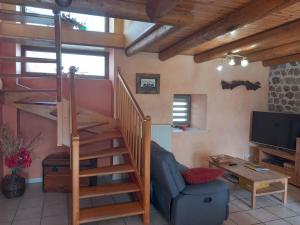 a living room with a staircase and a television at gite La Fermette in Valprivas +12 photos