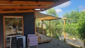 a house with a patio with chairs and an umbrella at Romantic Getaway Peace and a Unique View in Quillota