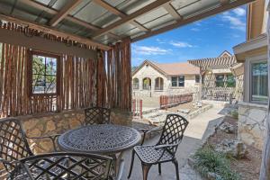 a patio with a table and chairs on a porch at Milk Bath Springs Cottage in Dripping Springs