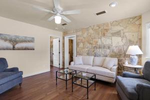 a living room with a couch and a stone wall at Milk Bath Springs Cottage in Dripping Springs