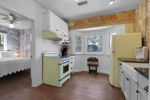 a kitchen with yellow appliances and a bed in a room at Milk Bath Springs Cottage in Dripping Springs