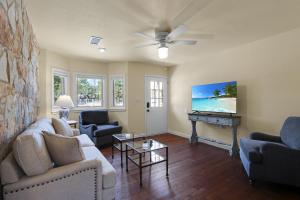 a living room with a couch and a piano at Milk Bath Springs Cottage in Dripping Springs +14 photos
