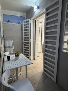 ein kleines Zimmer mit einem Tisch und einer Tür in der Unterkunft Aleila in Bacoli