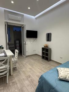 ein Schlafzimmer mit Bett, Tisch und Fernseher in der Unterkunft Aleila in Bacoli