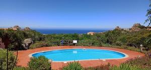 a small swimming pool with the ocean in the background at Poolvilla Bellavista - Vista Panoramica sul Mare in Costa Paradiso
