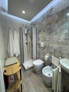 ein Badezimmer mit Waschbecken, Toilette und Dusche in der Unterkunft Aleila in Bacoli + 1 Foto