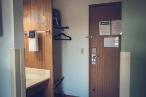 a bathroom with a wooden door and a sink at Forrest Inn in Amery