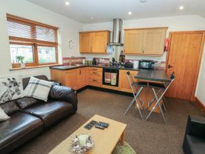 a living room with a couch and a kitchen at Green Route Apartment in Todmorden