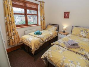 a bedroom with two beds and a window at Green Route Apartment in Todmorden