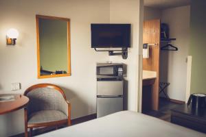 a small room with a small refrigerator and a television at Forrest Inn in Amery