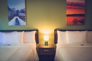 a hotel room with two beds and a lamp at Forrest Inn in Amery