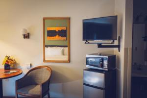 a room with a television and a chair and a table at Forrest Inn in Amery