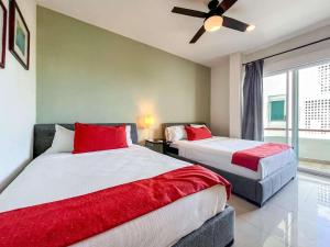 a bedroom with two beds and a ceiling fan at Isla Condo Puerta al Mar 403 at Sac Bajo in Isla Mujeres +20 photos