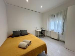a bedroom with a large bed and a desk at Habitación privada en apartamento compartido junto al Aeropuerto y Fira Barcelona in El Prat de Llobregat