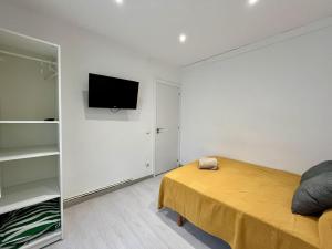 a bedroom with a bed and a tv on a wall at Habitación privada en apartamento compartido junto al Aeropuerto y Fira Barcelona in El Prat de Llobregat