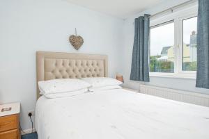 a white bed in a bedroom with a window at The Willows Dinas Cross in Newport