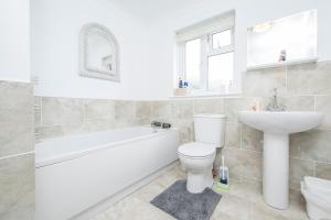 a bathroom with a white tub and a toilet and a sink at The Willows Dinas Cross in Newport +28 photos