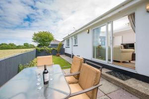 a glass table and chairs on the patio of a house at The Willows Dinas Cross in Newport