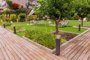a garden with tables and chairs and a tree at BLUESEA Dimona Suites in Torremolinos