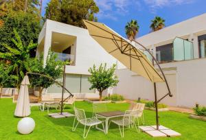 a garden with chairs and a table and umbrella at BLUESEA Dimona Suites in Torremolinos +19 photos