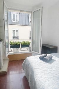 a bedroom with a bed and a large window at Studio La Gare in Paris