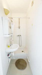 a white bathroom with a sink and a shower at Studio La Gare in Paris