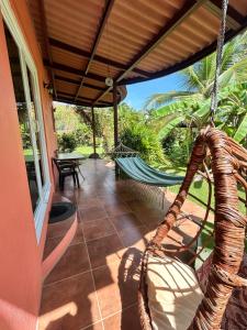 a porch with a hammock on a house at Cabanas Los Colibris Hotel Ecolodge in San Carlos