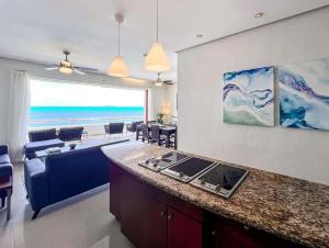 a kitchen and living room with a view of the ocean at Isla Condo Puerta al Mar 403 at Sac Bajo in Isla Mujeres