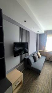 a living room with a couch and a flat screen tv at Mihailo Konaci hotel Andjela in Kopaonik +2 photos