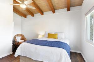 a white bedroom with a bed and a ceiling fan at Millies Cottages Unit 1 - Ruth in Canyon Lake