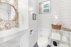 a white bathroom with a toilet and a mirror at Millies Cottages Unit 1 - Ruth in Canyon Lake