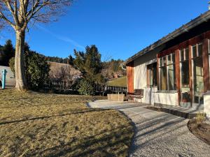a house with a tree next to a sidewalk at Ferienhaus Mätzler in Schwarzenberg
