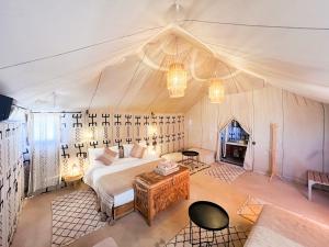 a bedroom with a bed and a fireplace in a tent at dreaming desert Luxury Camp in Adrouine