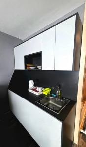 a kitchen counter with a sink and white cabinets at Mihailo Konaci hotel Andjela in Kopaonik