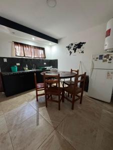 a kitchen with a table and chairs and a refrigerator at Complejo del Mar in Santa Clara del Mar