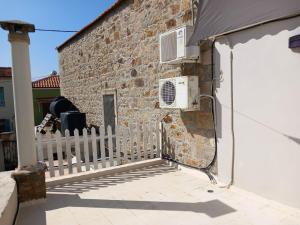 a building with a white fence and an air conditioner at Giannis' House in Polichnítos