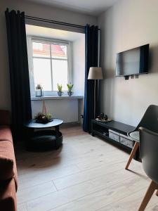 a living room with a window and a table at Kobal Apart in Bolesławiec