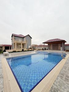 a large swimming pool in front of a house at Novxanı Villa in Baku