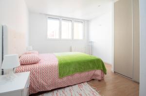 a white bedroom with a bed with a green blanket at AG Piso Fogar Carballo, 3 habitaciones in Carballo