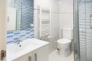 a white bathroom with a toilet and a sink at AG Piso Fogar Carballo, 3 habitaciones in Carballo